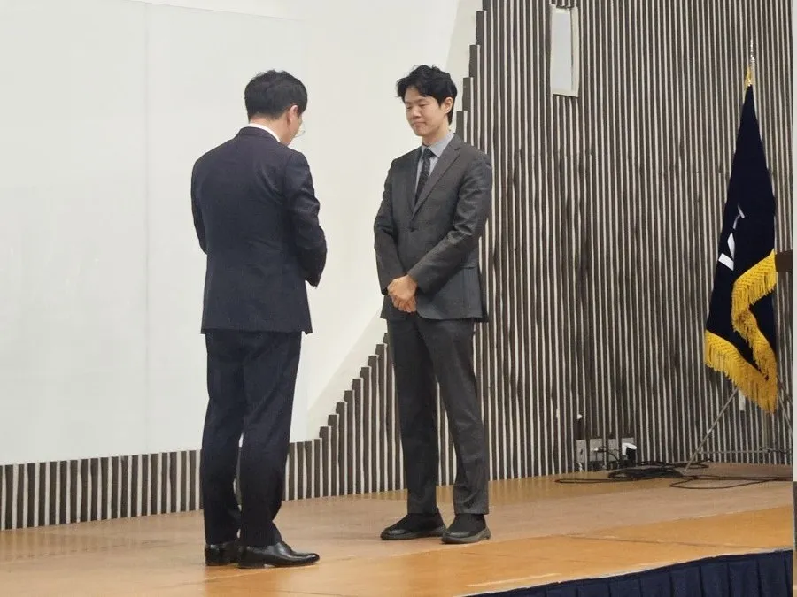 '논문 및 약사직능 홍보 영상 시상식' 현수막이 걸린 무대에서 상을 받는 강재현 약사.